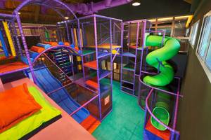 Kinderspielplatz im Banana Island Resort Doha mit bunten Spielgeräten und einer Rutsche.