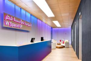 Empfangsbereich des W Doha Hotel & Residences mit blauer Theke und Loungebereich