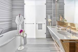 Badezimmer im Fairmont Doha Hotel mit Badewanne, Waschbecken und Dusche.