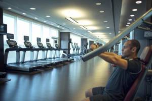 Fitnessstudio im Hyatt Regency Oryx Doha mit Läufern und Hantelbank