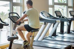 Fitnessstudio im Four Seasons Hotel Doha mit einem Mann auf einem Spinnrad.
