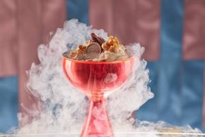 Eisbecher im Mandarin Oriental Doha mit weißem Rauch und einem Schokoriegel obenauf