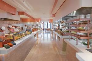 Innenansicht des Restaurants im Mandarin Oriental Doha Hotel mit Köchen, die Gerichte zubereiten und servieren.