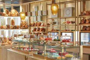 Patisserie im Mandarin Oriental Doha mit Brot und Gebäck hinter Glasvitrinen.