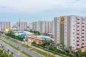 Außenansicht des Grand Park Lara Hotels mit mehreren Gebäuden, Swimmingpool und Flaggen.