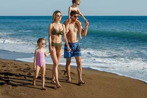 Familie im Grand Park Lara Hotel genießt einen Spaziergang am Strand
