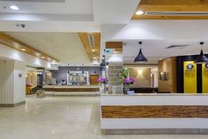 Reception des Grand Park Lara Hotels mit Blumenarrangements und moderner Einrichtung.