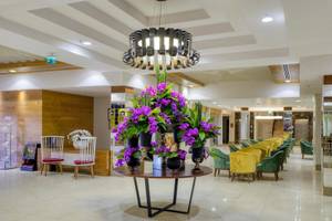 Lobby des Grand Park Lara Hotels mit Tisch, Blumen und Stühlen