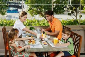 Familie am Frühstückstisch im Grand Park Lara Hotel mit Buffet und Orangensaft.