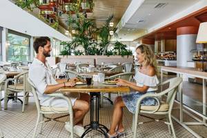 Ein Paar sitzt in einem Restaurant des Grand Park Lara Hotels an einem Tisch.