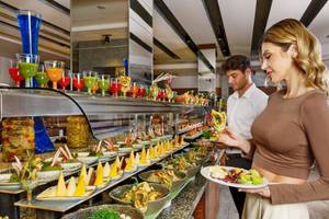 Paar genießt von einer Auswahl an Speisen an einem Buffet im Grand Park Lara Hotel