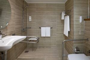 Behindertengerechtes Badezimmer im Grand Park Lara Hotel mit ebenerdiger Dusche, Handtuchhalter und barrierefreien Annehmlichkeiten.