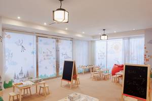Das Kinder Lernzentrum im St. Regis Doha mit bunten Wänden, Tischen und Stühlen.