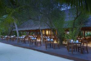 Alfresco-Essbereich im Summer Island Maldives Hotel mit Tischen und Stühlen im Freien.