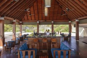 Innenansicht der Bar im Summer Island Maldives Hotel mit Holzmöbeln und Deckenventilatoren.