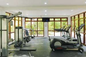 Fitnessstudio im Summer Island Maldives Hotel mit Fenstern und Trainingsgeräten.
