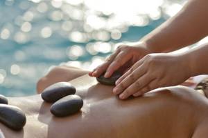 Massage am Strand im Summer Island Maldives mit Steinen auf dem Rücken