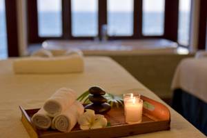 Massagetisch im Summer Island Maldives Hotel mit Kerzen, Blumen und Handtüchern