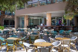 Außenbereich des Turquoise Hotels mit vielen Tischen und Stühlen auf der Terrasse.