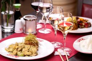 Ein Tisch im Turquoise Hotel mit Tellern, Weinglaesern und Speisen.