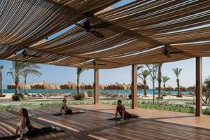 Yoga-Übungen auf der Terrasse des JAZ Riviera Hotels mit Blick auf den Strand und das Meer.
