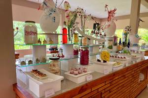 Buffet im Brennia Kottefaru Maldives mit verschiedenen Desserts und Getränken auf mehreren Etagen.