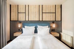 Bett im Schlafzimmer im Paradisus Varadero Resort & Spa mit weißen Laken und Kissen auf einem blauen Kopfteil.