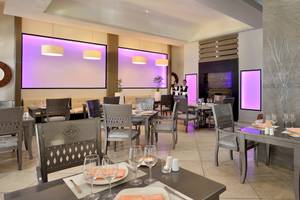 Innenraum des Restaurants im Paradisus Varadero Resort & Spa mit moderner Einrichtung und violetten Beleuchtung.
