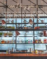 Cocktailbar im Hilton Dubai Palm Jumeirah mit vielen Flaschen und neonfarbener Beleuchtung.