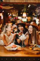 Gruppe von Frauen, die in der Innenbar des Hilton Dubai Palm Jumeirah Cocktails trinken.