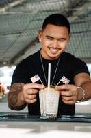 Barkeeper des Hilton Dubai Palm Jumeirah serviert einen Cocktail mit amerikanischen und britischen Flaggen.