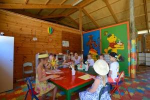 Kinder basteln am Tisch in einem holzverkleideten Raum im Nozha Beach & Spa Hotel.