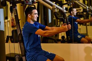 Mann im Fitnessstudio von Sealine Beach, A Murwab Resort, trainiert sich mit einer Trainingsmaschine.