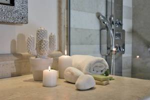 Badezimmer im Pilot Beach Resort mit Kerzen, Kaktus und Handtüchern.