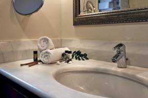 Badezimmer im Pilot Beach Resort mit weißem Waschbecken und Marmoroberfläche.