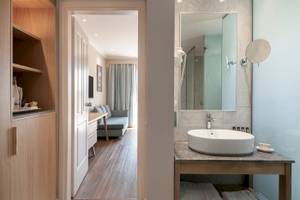 Badezimmer des Pilot Beach Resorts mit Waschbecken, Spiegel und Zugang zur Schlafzimmer.