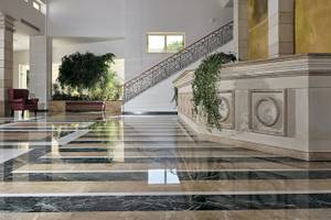 Foyer des Pilot Beach Resorts mit Marmorboden und geschwungener Treppe