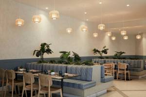 Innenbereich des Mare Paphos Hotels mit Sitzgelegenheiten, Tischen, Pflanzen und dekorativen Lampen.