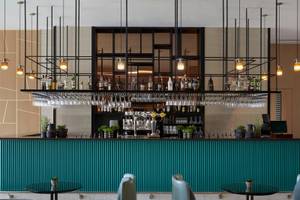 Innenansicht der Bar im Mare Paphos Hotel mit grüner Theke und schwarzen Stühlen.