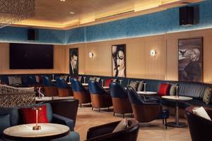 Loungebereich im St. Regis Al Mouj Muscat Resort mit modernen Möbeln und Kunstwerken.