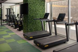 Fitness-Center im St. Regis Al Mouj Muscat Resort mit Laufbändern und Kraftgeräten.