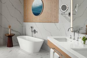 Badezimmer im St. Regis Al Mouj Muscat Resort mit Badewanne und Waschbecken.