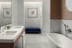 Das Badezimmer im St. Regis Al Mouj Muscat Resort mit weißen Marmorfliesen, einem blauen Hocker, zwei Waschbecken und einer Badewanne.
