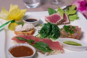 Fischplatte von Le Bora Bora by Pearl Resorts mit verschiedenen Fischsorten und Beilagen.