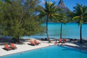 Poollandschaft des InterContinental Bora Bora Resort mit Blick auf den Berg und den Ozean.