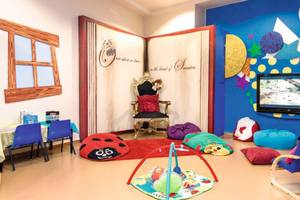 Kinderzimmer im Atlantica Caldera Palace Hotel mit bunten Möbeln, einem Thron, und einem Fernseher.