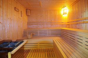 Innenansicht der Sauna im KC Grande Resort Koh Chang mit Holzbänken und einer Holzschale