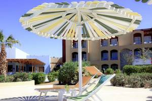 Sonnenschirm und Liegestuhl vor dem Lemon & Soul Garden Makadi Hotel.