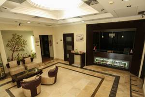 Lobby des Paradis Palace Hotels mit Sitzbereich, Rezeptionstresen und Spa-Anzeige