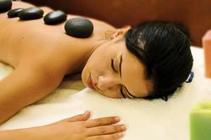 Frau genießt eine Massage mit Steinen auf dem Rücken im Hotel Paradis Palace